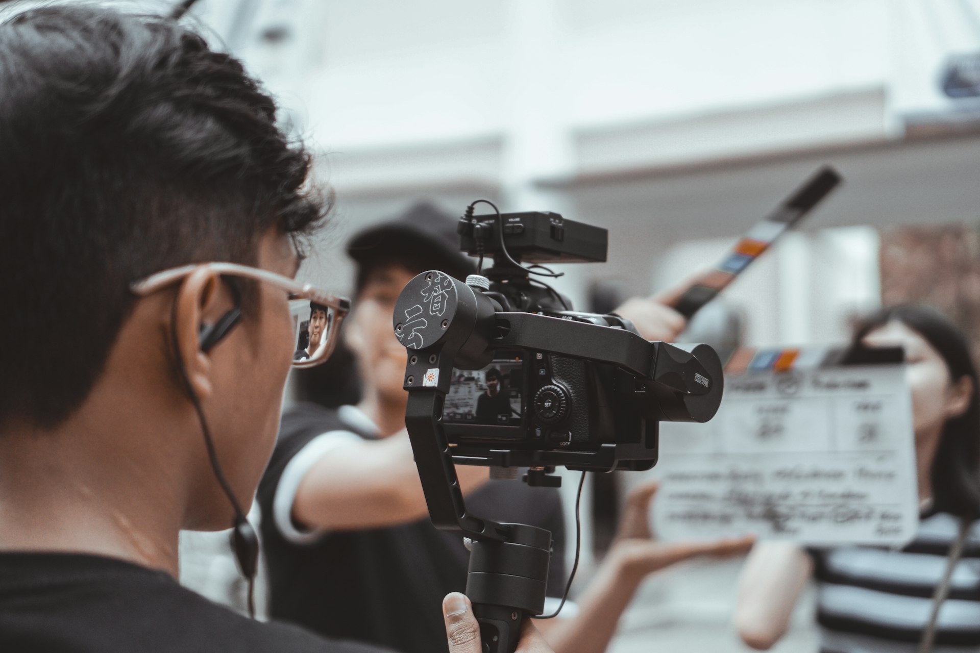 man in black framed eyeglasses holding black video camera